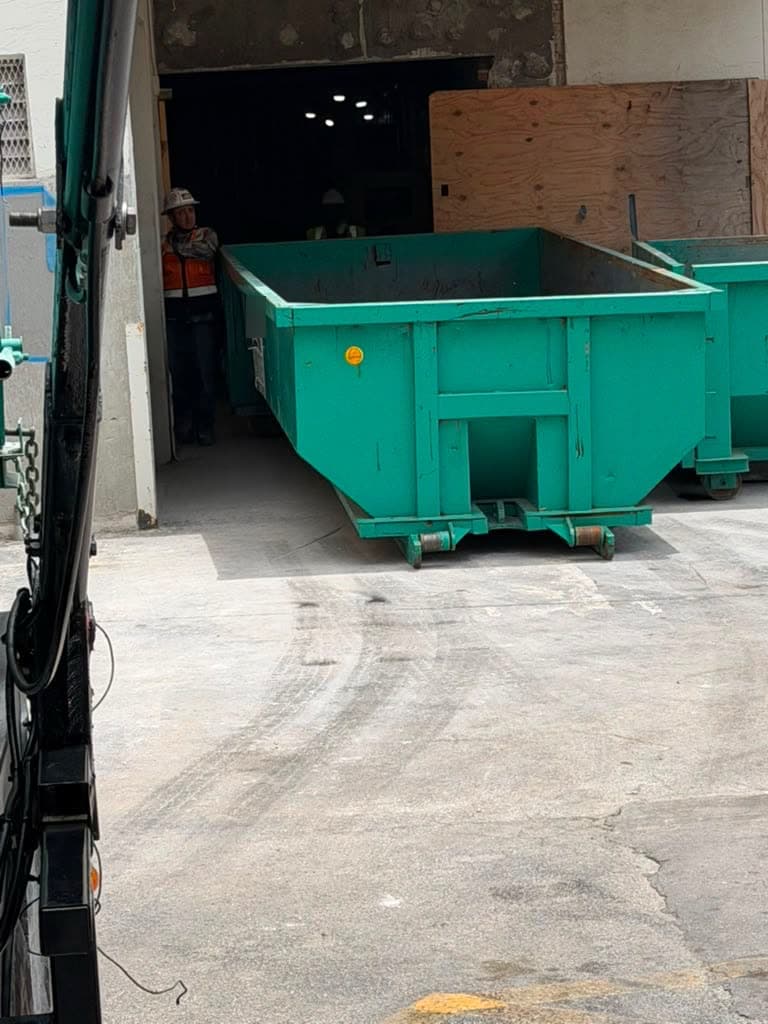 Roll-off dumpster dropped off at a commercial building loading area