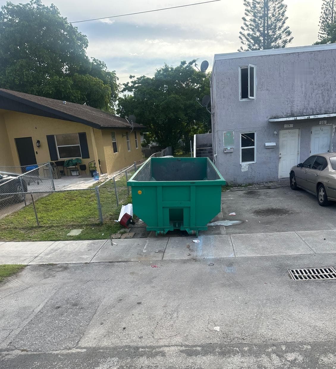 Roll-off dumpster placed beside a residential driveway